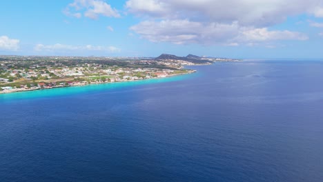 Beautiful-Caribbean-blue-ocean-waters-and-sandy-shoreline-beaches-of-Curacao,-panoramic-aerial-ascend