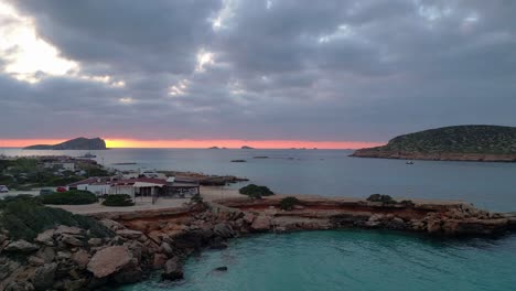 Playa-De-Cala-Comte-Con-Barcos,-Impresionante-Cielo-Al-Atardecer-En-Ibiza