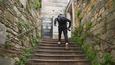 Junger-Hispanischer-Tourist-Rennt-Mit-Einer-Kamera-In-Der-Hand-Die-Treppe-Hinauf