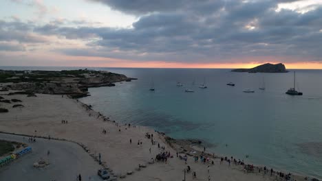 Playa-De-Cala-Comte-Con-Barcos,-Impresionante-Cielo-Al-Atardecer-En-Ibiza