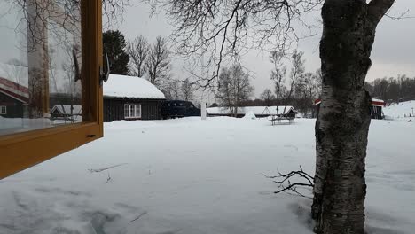 Blick-Aus-Dem-Offenen-Fenster,-Während-Es-Außerhalb-Der-Gemütlichen-Hütte-Schneit