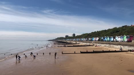 Familias-Disfrutando-De-La-Playa-En-Un-Día-Cálido-En-Frinton-On-Sea-En-Essex,-Reino-Unido