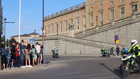 Multitud-Esperando-La-Procesión-Real-En-El-Palacio-Sueco-El-Día-Nacional,-Presencia-Policial,-Día-Soleado,-Punto-De-Referencia-De-La-Ciudad