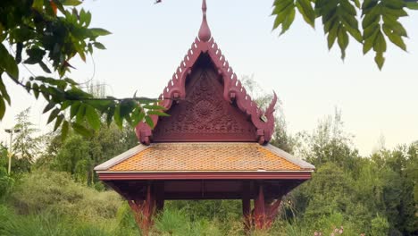 Kamerafahrt-Einer-Verzierten-Pagode-Von-Der-Plaza-Thailand-Durch-Hängende-Äste,-Araucano-Park