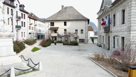 Small-European-square-and-government-building-with-flags-moving-in-the-wind