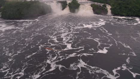 Video-Aéreo-De-Una-Curiara,-O-Pequeña-Embarcación,-Navegando-En-La-Laguna-De-Canaima,-Junto-A-Las-Cascadas.