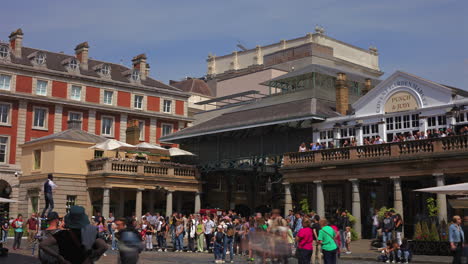 Timelapse-of-crowd-watches-a-street-performer,-Covent-Garden-Market,-London-on-a-hot,-sunny-lunchtime