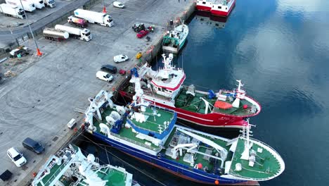 Fishing-boats-in-harbour-being-worked-on-to-go-to-sea-in-Castletownbere-harbour-in-Cork-Ireland-on-the-Wild-Atlantic-Way-early-morning-in-summer