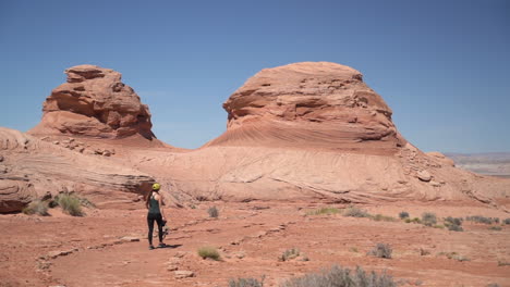 Back-View-of-Young-Woman-Photographer-Walking-in-Desert-With-Camera-on-Hot-Sunny-Day