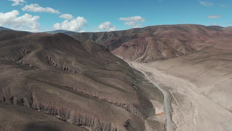Desolate-and-arid-landscape-crossed-by-a-paved-road-heading-to-Salinas-in-the-province-of-Jujuy,-Argentina