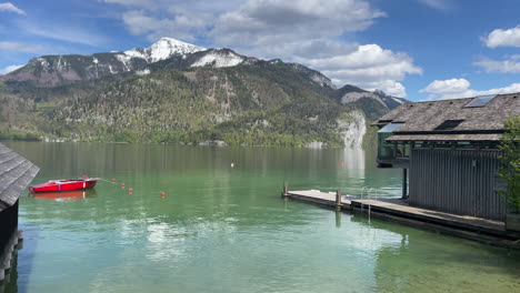 Schöne-Aussicht-Auf-Die-österreichischen-Alpen-Und-Eine-Kleine-Fischerhütte-Mit-Rotem-Boot-Im-Sommer-In-Österreich