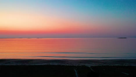 Wunderschöner-Sonnenaufgang-Am-Strand-Mit-Einer-Drohne,-Die-Durch-Die-Bäume-über-Einem-Sandigen-Wanderweg-Aufsteigt