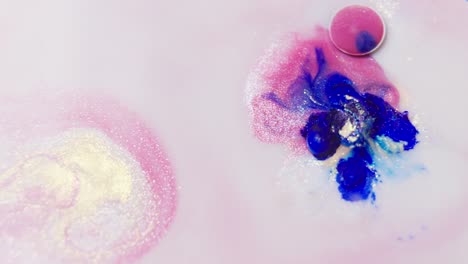 Vibrant-pink-and-blue-ink-swirls-in-water,-forming-abstract-patterns