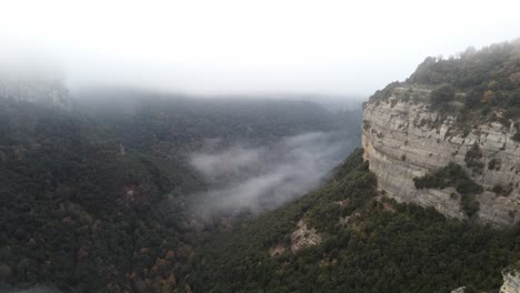 Cañón-Brumoso-En-Osona,-Barcelona-Con-Niebla-Sobre-Densos-Bosques-Y-Acantilados-Escarpados,-Amplia-Vista-Aérea