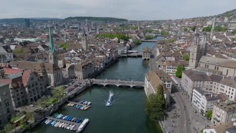 Schnell-Vorwärts-Bewegte-Drohnenaufnahme-Der-Stadt-Zürich,-Zeigt-Die-Architektur-Der-Altstadt,-Uhrtürme-Und-Die-Skyline-Der-Stadt-Mit-Dem-Fluss-Im-Vordergrund