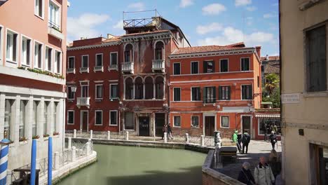 Scenic-architectural-residential-building-with-tourists-walking-the-streets-and-canals-of-Venice