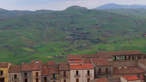 Aerial-Pullback-Reveals-Concrete-Houses-Lined-together-with-Scenic-Landscape-in-Background