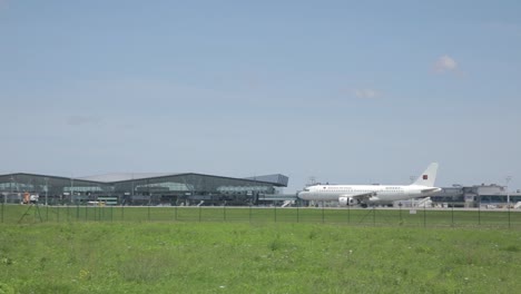 Toma-Panorámica-Del-Rodaje-Del-Avión-De-Electra-Airways-Termina-En-Furgonetas-Hsm-Global-Estacionadas