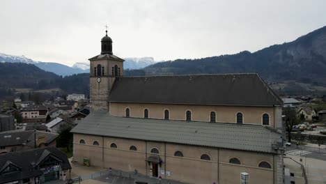 Closeup-of-a-tan-brown-church-with-mountains-in-the-far-background