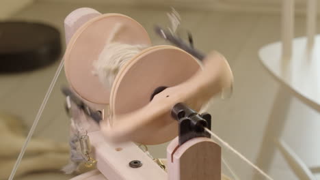 Tension-spring-bobs-as-spinning-wheel-bobbin-rotates-making-wool-yarn