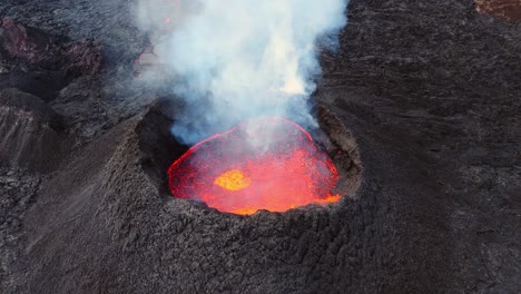 Rauchender-Vulkankrater-Mit-Berstender-Glühender-Lava-In-Aschfahler-Landschaft