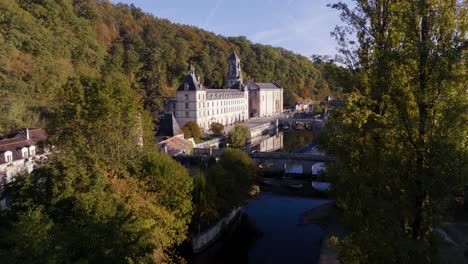 Brantôme-Abbey-in-Périgord-near-Périgeux,-wide-drone-view-of-the-river-and-the-building