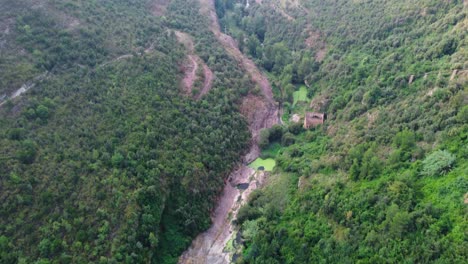 Sant-Miquel-Del-Fai-Mit-üppigem-Grün-Und-Einem-Fluss,-Der-Durch-Felsiges-Gelände-Fließt,-Barcelona,-Luftaufnahme