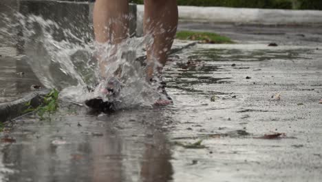 Woman-in-sandals-walking-through-water-puddle-splashing-around-in-slow-motion