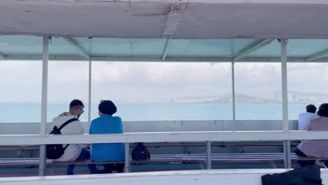 Pareja-Turca-En-Ferry-Con-El-Horizonte-De-Estambul-En-El-Fondo-En-Un-Día-Nublado