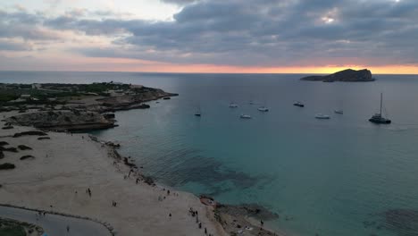 Strand-Von-Cala-Comte-Mit-Booten,-Atemberaubender-Sonnenuntergangshimmel-Auf-Ibiza