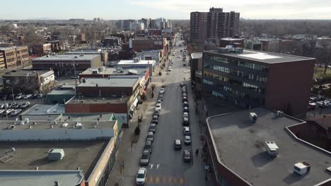 drone-fly-above-main-road-street-in-Saint-Lambert,-Quebec-Canada-with-car-traffic-driving-during-a-sunny-day