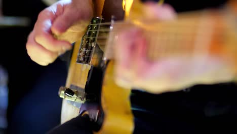 Close-up-of-guitar-strings-being-plucked-by-the-fingers-of-a-young-guitarist