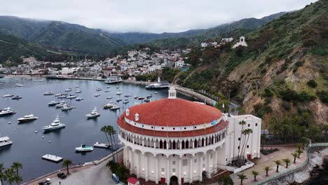 Avalon-on-catalina-island,-showing-yachts-in-the-harbor-and-the-iconic-round-building,-aerial-view