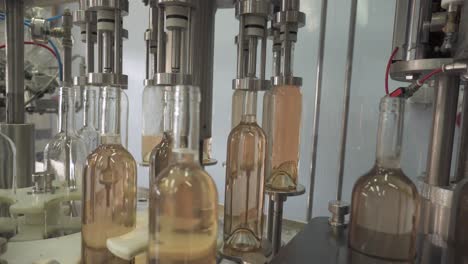 Rose-Wine-Bottling-Plant-Filling-Up-Bottles-In-A-Machinery
