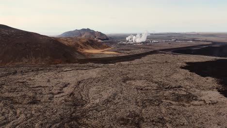 Road-and-thermal-powerplant-in-desolate-volcanic-landscape,-Iceland