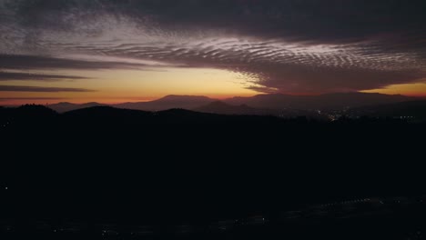 Aerial-view-of-a-tranquil-sunset-between-hills-islands-Santiago-Chile,-background-with-clouds-and-faint-sunlight