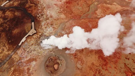 Aerial-shot-of-steam-rising-from-the-vibrant-Gunnhuver-hot-springs-in-Iceland