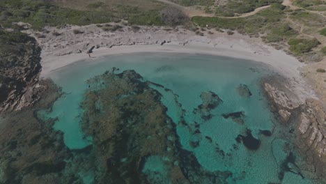 Blue-bay-lagoon-in-mediterranean-white-sand-green-forested-hills,-aerial-drone-nature-shot