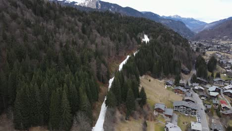 Una-Sola-Franja-Blanca-De-Nieve-Con-Pocas-Personas-Esquiando-Entre-El-Bosque-En-Una-Estación-De-Esquí-Francesa