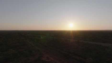 Clip-De-Drone-Con-Múltiples-Destellos-De-Lentes-Que-Muestran-Un-Brillante-Amanecer-Sobre-El-Interior-De-Australia