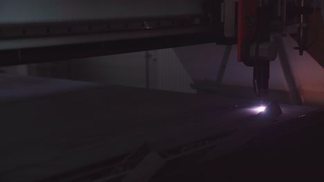 CNC-plasma-cutter-machine-with-flying-sparks,-dark-background