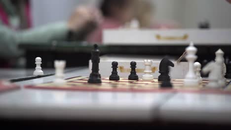 Close-up-of-a-chessboard-where-two-boys-play-during-a-chess-lesson