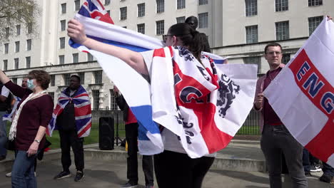 People-hold-up-English,-British-and-Israeli-flags-at-a-small-far-right-protest-next-to-the-Viscount-Montgomery-statue-on-Whitehall