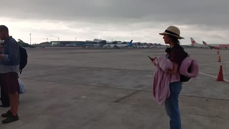 Passagiere-Stehen-Schlange,-Um-Am-Internationalen-Flughafen-Sultan-Hasanuddin-In-Makassar-An-Bord-Eines-Flugzeugs-Zu-Gehen_Schwenkaufnahme
