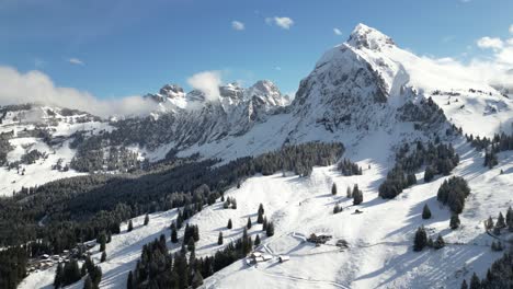 Aerial-drone-shot-flying-over-mountain-range-along-mountain-slope-in-Fronalpstock,-Switzerland-Glarus-on-a-sunny-day