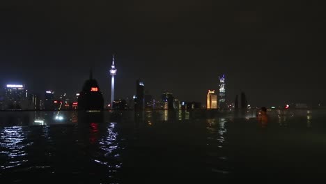 Vista-Desde-La-Piscina-De-Lujo-En-La-Azotea-Sobre-El-Paisaje-Urbano-De-Rascacielos-Iluminado,-Kuala-Lumpur