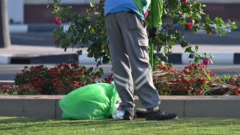 Un-Trabajador-Municipal-Barre-Diligentemente-Botellas-De-Plástico-Y-Tierra-Derramada-En-El-Jardín