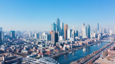 La-Vista-Panorámica-De-Las-Nubes-Del-Cielo-Azul-Que-Pasan-Sobre-Las-Torres-Residenciales-Comerciales-Del-Centro-De-La-Ciudad-Y-Los-Rascacielos-Modernos,-Los-Edificios-Del-Horizonte,-La-Escena-De-La-Metrópolis-De-La-Ciudad-Con-Un-Puente-A-Través-Del-Río.