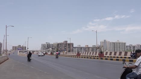 Many-men-are-walking-over-a-road-and-large-buildings-are-visible-in-the-background