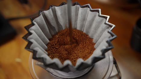 Stirring-Fresh-Ground-Coffee-In-Paper-Filter-Before-Brewing,-Close-Up